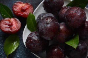 juicy plums in a plate. fresh blue plums.